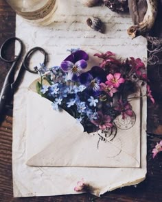 an old envelope with flowers and scissors on it