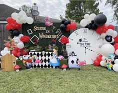 a large clock surrounded by balloons and other decorations in front of a house with a black and white theme