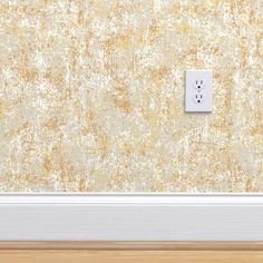 an electrical outlet on the wall in front of a wooden floor with a yellow background