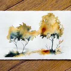 watercolor painting of two trees on white paper with brown and yellow leaves in the background