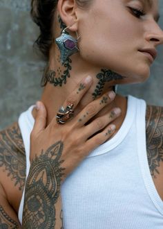 a woman with tattoos and piercings on her neck