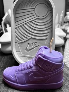 a pair of purple sneakers sitting on top of a wooden table