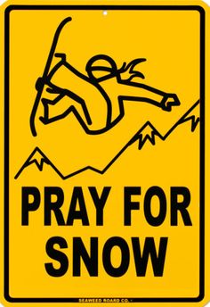 a yellow sign that says pray for snow with a man falling off the mountain behind it