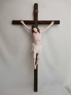 a wooden crucifix with a man on it's cross in front of a white background