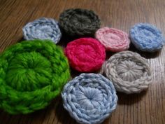 several crocheted flowers sitting on top of a wooden table