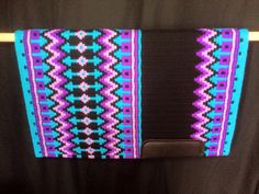 a black and purple purse with blue, pink, and white designs on it's side