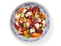 a blue and white bowl filled with vegetables