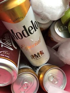 several cans of soda and some fruit on a table