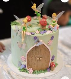 a cake decorated with tinkerbells and flowers