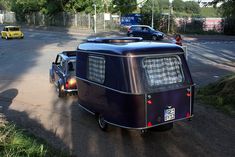 an old vw camper is parked on the side of the road