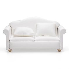 a white couch with two pillows on it's back and the seat upholstered