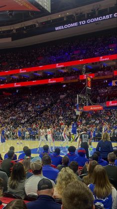 a basketball game is being played in an arena with many people sitting on the bleachers