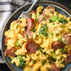 a bowl filled with eggs, sausage and broccoli on top of a table