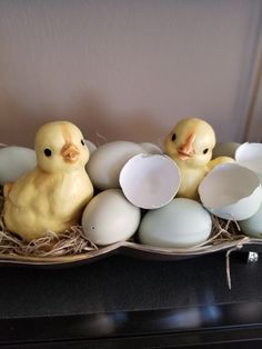 three rubber ducks sitting on top of eggs in a nest