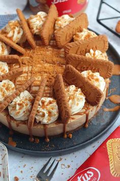 a cake with whipped cream and cookies on it sitting on a plate next to a can of coke