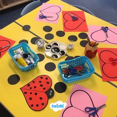 the table is covered with paper hearts and scissors