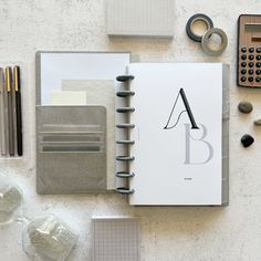 an open notebook sitting on top of a table next to office supplies