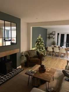 a living room filled with furniture and a christmas tree in the middle of the room