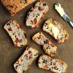 several slices of bread with butter and raisins next to them on a table