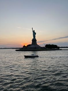 the statue of liberty is silhouetted against an orange and blue sky as it stands in the water