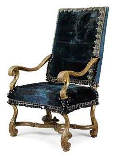 an antique chair with blue velvet and gold trimmings