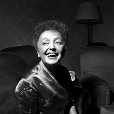 an older woman sitting in a chair with her eyes closed and mouth wide open, smiling