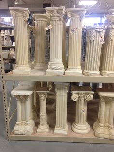 many white pillars are stacked on top of each other in a store display case with tags attached to them