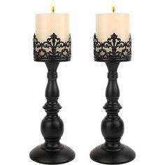 two black candle holders with white candles in them on a white background, one is decorated with filigrees and the other has an intricate design