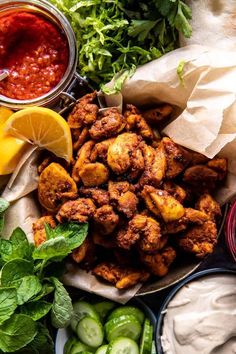 the ingredients to make chicken wings are laid out on a plate with sauces and cucumbers