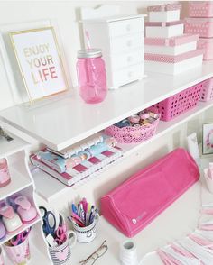 a white desk topped with lots of pink items