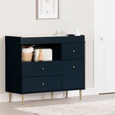 a black cabinet with gold legs in a white room