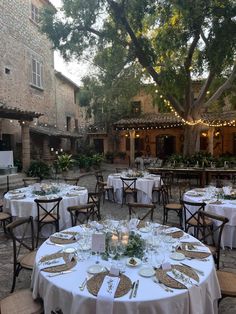 an outdoor dining area with tables and chairs set up for a formal function in the evening