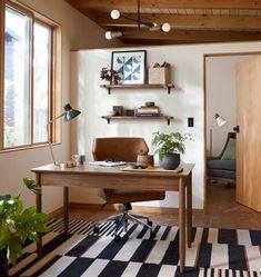 a home office with a desk, chair and potted plants