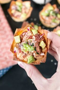 a hand holding up a tortilla filled with meat, cheese and veggies