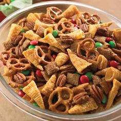 a glass bowl filled with cereal and pretzels