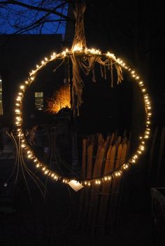 a circular mirror with lights hanging from it's sides in front of a building