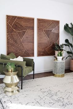 some plants are sitting in front of two wooden wall art pieces on the wall above a green chair