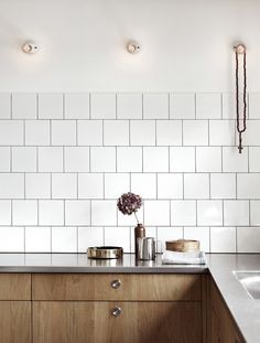 a kitchen with white tiles and wooden cabinets