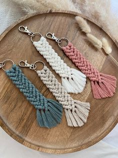 four tasselled keychains on a wooden tray with feathers in the background