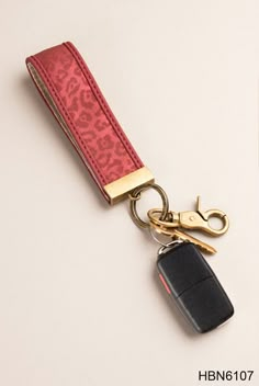 a red keychain with a black car charm attached to it's side