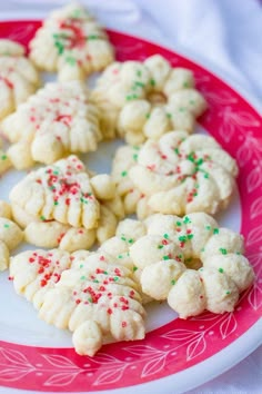 white cookies with green and red sprinkles on a pink and white plate