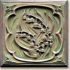 a decorative tile with flowers and leaves on it