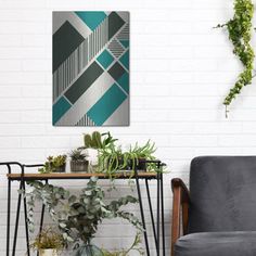 a living room filled with furniture and plants on top of a wooden table in front of a white brick wall