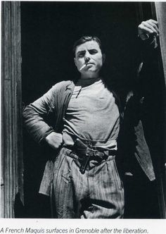 an old photo of a man standing in front of a door with his hands on his hips