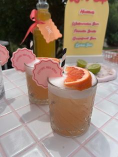 two glasses filled with drinks sitting on top of a table