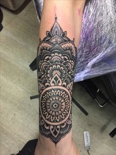 a woman's leg with a tattoo on it and an intricate design in the middle