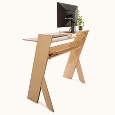 a wooden desk with a computer monitor and keyboard on it's side, sitting in front of a white background