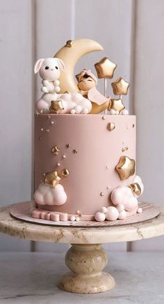 a pink cake with gold stars and sheep on top