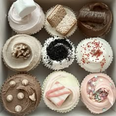 a box filled with lots of different types of cupcakes