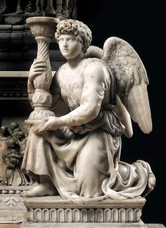 an angel statue holding a lamp in his hands